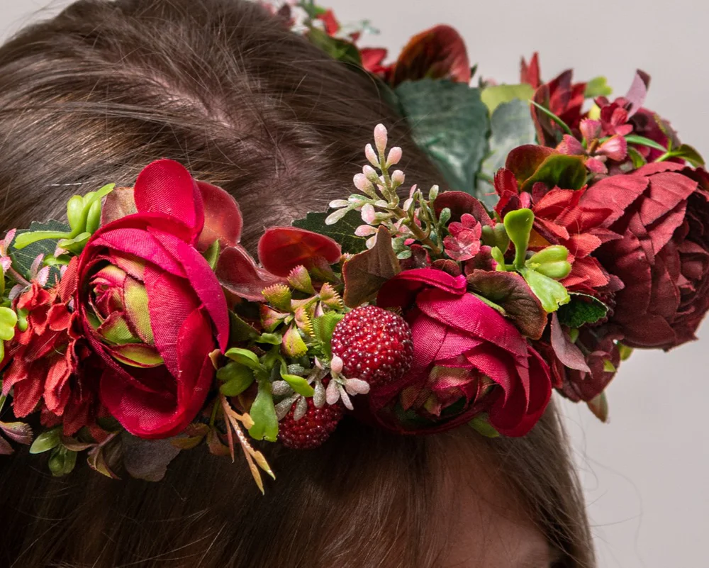 Mākslīgs vainags no košiem ziediem un zaļumiņiem